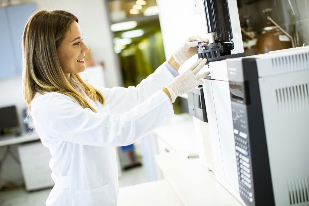 young-female-scientist-in-a-white-lab-coat-putting-26MLMSD.jpg